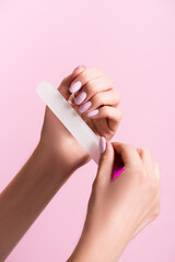 cropped view of woman using nail file isolated on pink, stock image