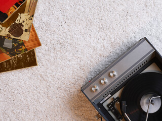Retro record player on carpet in bedroom