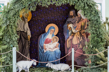 Fototapeta na wymiar Nativity scene near the church with figures in the form of Jesus, Mary, Joseph.
