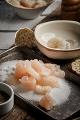 Fish raw for paella on the dark wood table