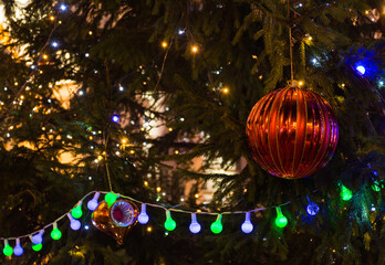 Colorful red Christmas tree decorations and lights, at night.