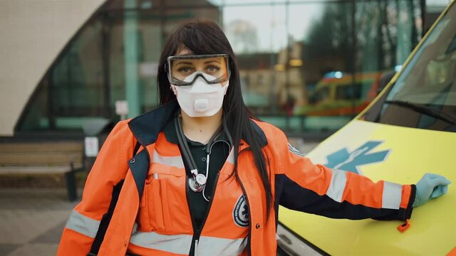 Sad female paramedic stares at you. Writing on clothes means Urgent care