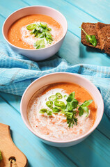 Red lentil tomato soup - delicious vegetarian food on blue wooden background. Healthy lunch