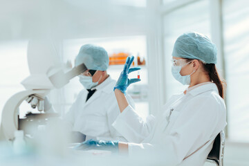 ampoule with a vaccine in the hands of a female scientist.