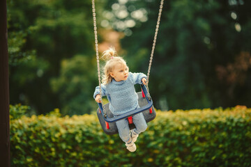 blonde haired girl on the swing