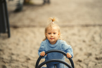 blonde haired girl on a swing