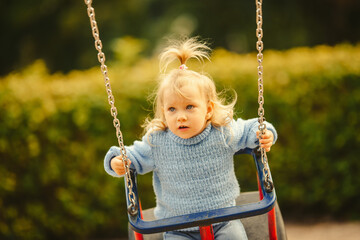 blonde haired girl on the swing