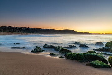 Sunrise by the Sea and Rocks on the Shoreline