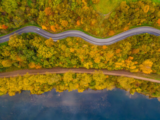 Aerial scenery view of winding road and railway beside in autumn fall