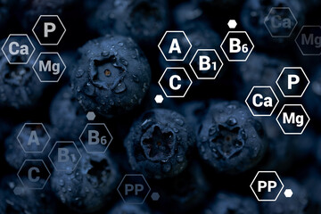 Fresh blueberries background with letter designations of vitamins and minerals. Healthy food concept