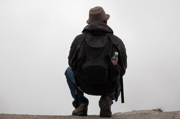traveler man photographer with back hat in spectacular landscape crater lake with fog quilotoa volcano ecuador latin america