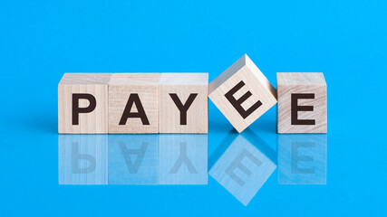 The text Payee is written on the cubes in black letters, the cubes are located on a blue glass...