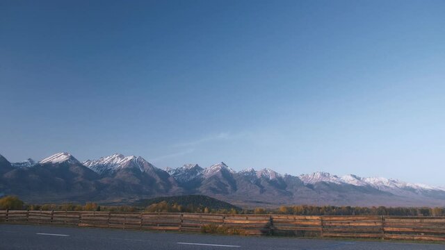 The man travel on mixed terrain cycle touring with bikepacking. The traveler journey with bicycle bags. Sport tourism bikepacking, bike, sportswear in green black colors. Mountain snow capped.