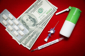 Pills, thermometer, inhaler and money on a red background. Medicine and pharmaceuticals concept. Expensive medicines, spending money on health care.