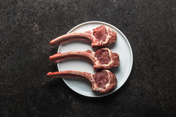Slices raw lamb chops on black table. © Jiri Hera