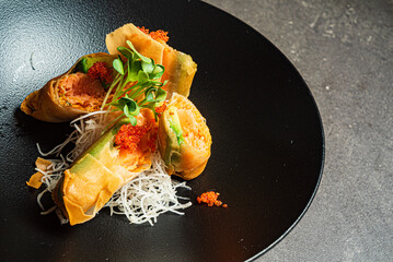 asian spring rolls on black plate