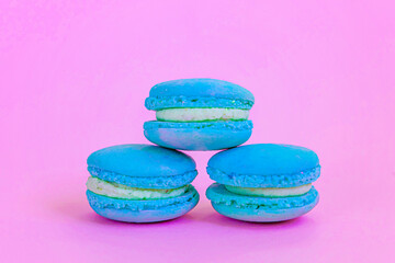 Sweet almond colorful unicorn blue macaron or macaroon dessert cake isolated on trendy pink pastel background. French sweet cookie. Minimal food bakery concept Copy space
