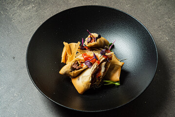 asian spring rolls on black plate