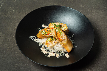 asian spring rolls on black plate