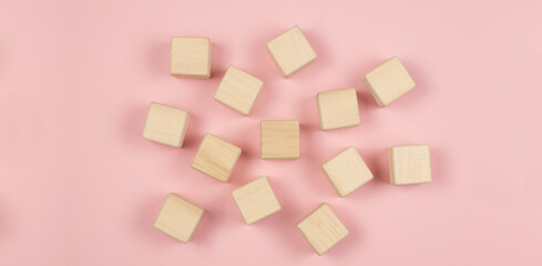 Wooden cubes on a pink background. Place for text