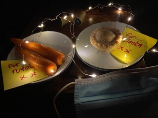 covid-19 Christmas eve, santa hat with face mask and for Santa note with mince pie and carrots for...