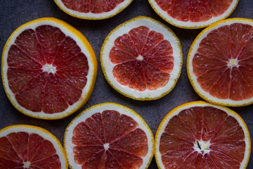 Blood orange on a table. Juicy red fruit texture close up. Gray background with copy space. Healthy eating concept. 