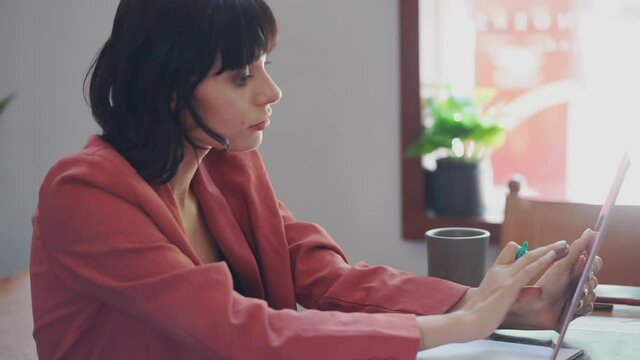 Portrait of beautiful caucasian businesswoman using tablet in cafe.
