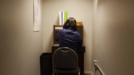 Stressed out woman operator at old telephone switchboard in tiny room