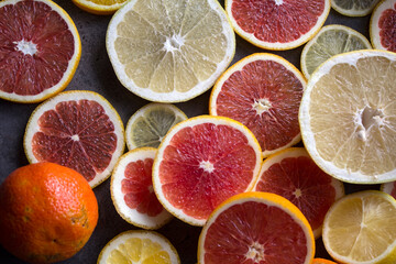 Background made of ripe juicy oranges slices. Top view photo of different types of citrus. 