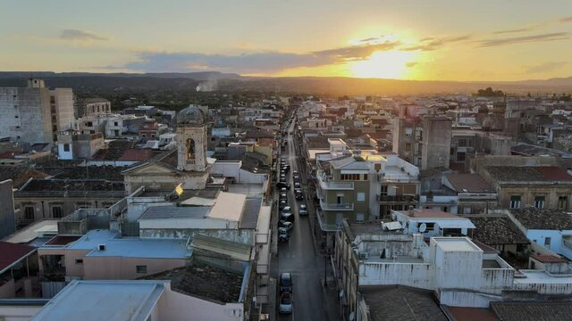 Drone flies over the streets and historic center of Floridia in province of Syracuse (Siracusa) in Sicily at sunset