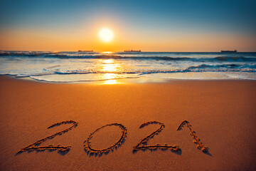 Happy New Year 2021 concept, lettering on the beach. Sea sunrise