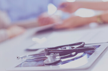 Close up of doctor and patient sitting at the desk near the window in hospital