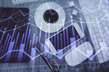 Multi exposure of forex graph hologram over desktop with phone. Top view. Mobile trade platform concept.