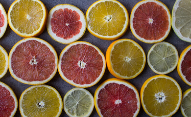 Fototapeta na wymiar Colorful background made of red orange, lime, grapefruit and lemon slices. Beautiful colors of fruit texture. Citrus close up photo. Healthy eating concept. 