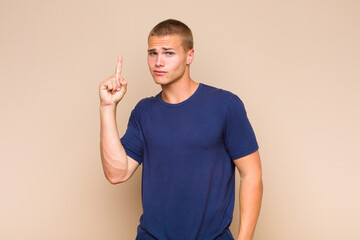 blonde  man feeling like a genius holding finger proudly up in the air after realizing a great...