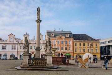 Main town Charles' square with baroque fountain and Marian Column, historic houses with stucco, Christmas decorations in Kolin, Central Bohemia, Czech Republic
