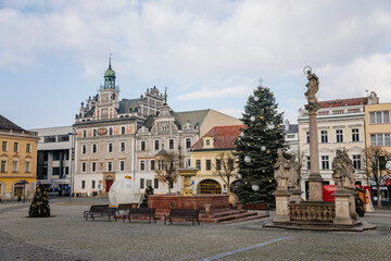 Main town Charles' square with baroque fountain and Marian Column, historic houses with stucco, Christmas tree and Christmas decorations in Kolin, Central Bohemia, Czech Republic