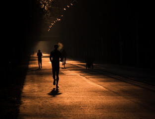 silhouette of persons running on the road at sunrise