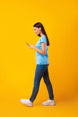 Woman using mobile phone at studio, full length