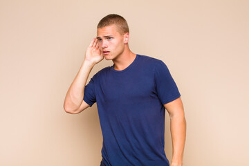 blonde  man looking serious and curious, listening, trying to hear a secret conversation or gossip,...