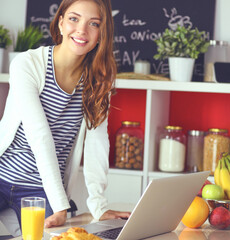Young woman sitting near desk in the kitchen