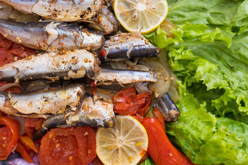 Fish stewed in vegetables with lemon. Culinary background with selective focus