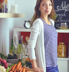 Young woman standing near desk in the kitchen