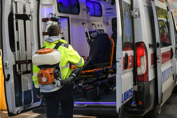 Paramedics disinfecting the ambulance car who brought coronavirus patients with the motorized...