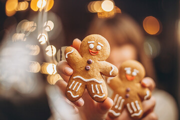 concept for cafe or bakery for Christmas holidays: smiling woman holding gingerbread cookies and...