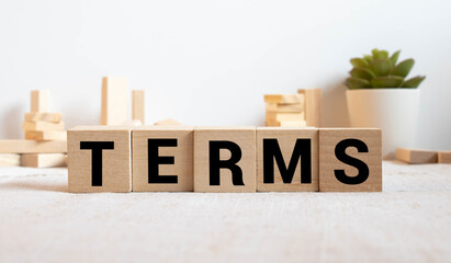 Terms sign in a bright office on a wooden desk with windows in the background