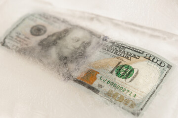 US dollars frozen under a layer of ice, the concept of the global financial crisis or the fall of the dollar in the world market