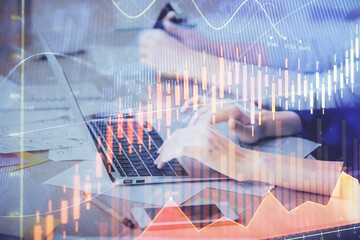 Multi exposure of woman hands typing on computer and financial chart hologram drawing. Stock market...