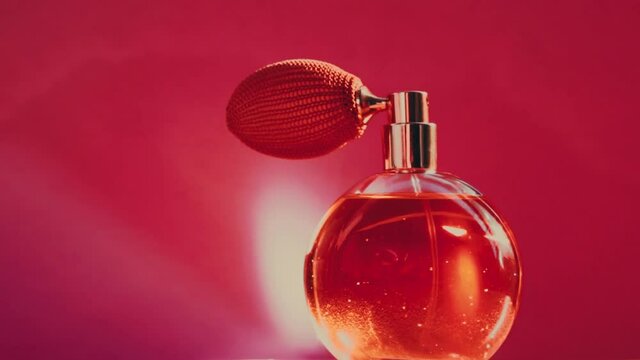 Vintage perfume bottle and shining light flares on red background, glamorous fragrance scent as luxury perfumery product for cosmetic and beauty brand, stock footage