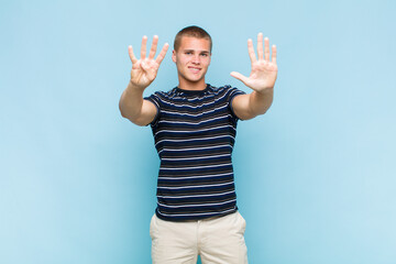 blonde  man smiling and looking friendly, showing number nine or ninth with hand forward, counting...